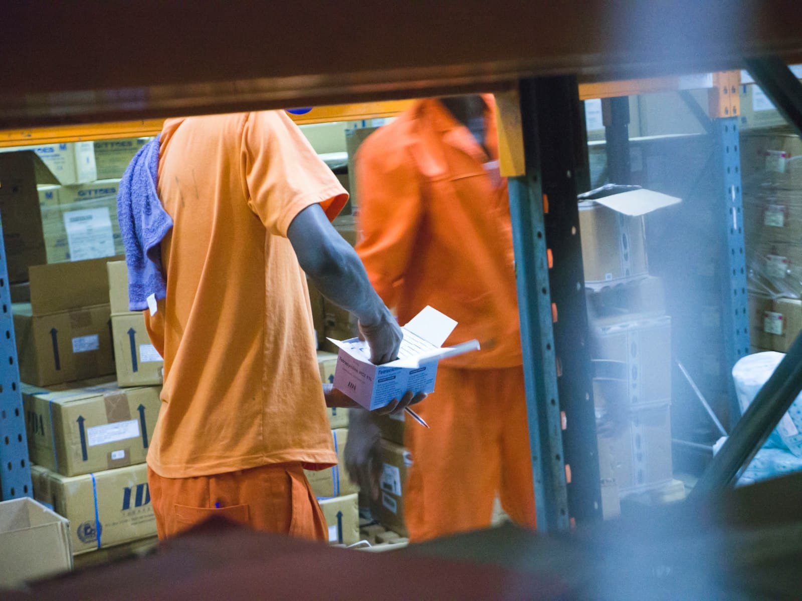 Two warehouse staff checking freight, illustrating the scattered systems a company knowledge base ai has to bring together
