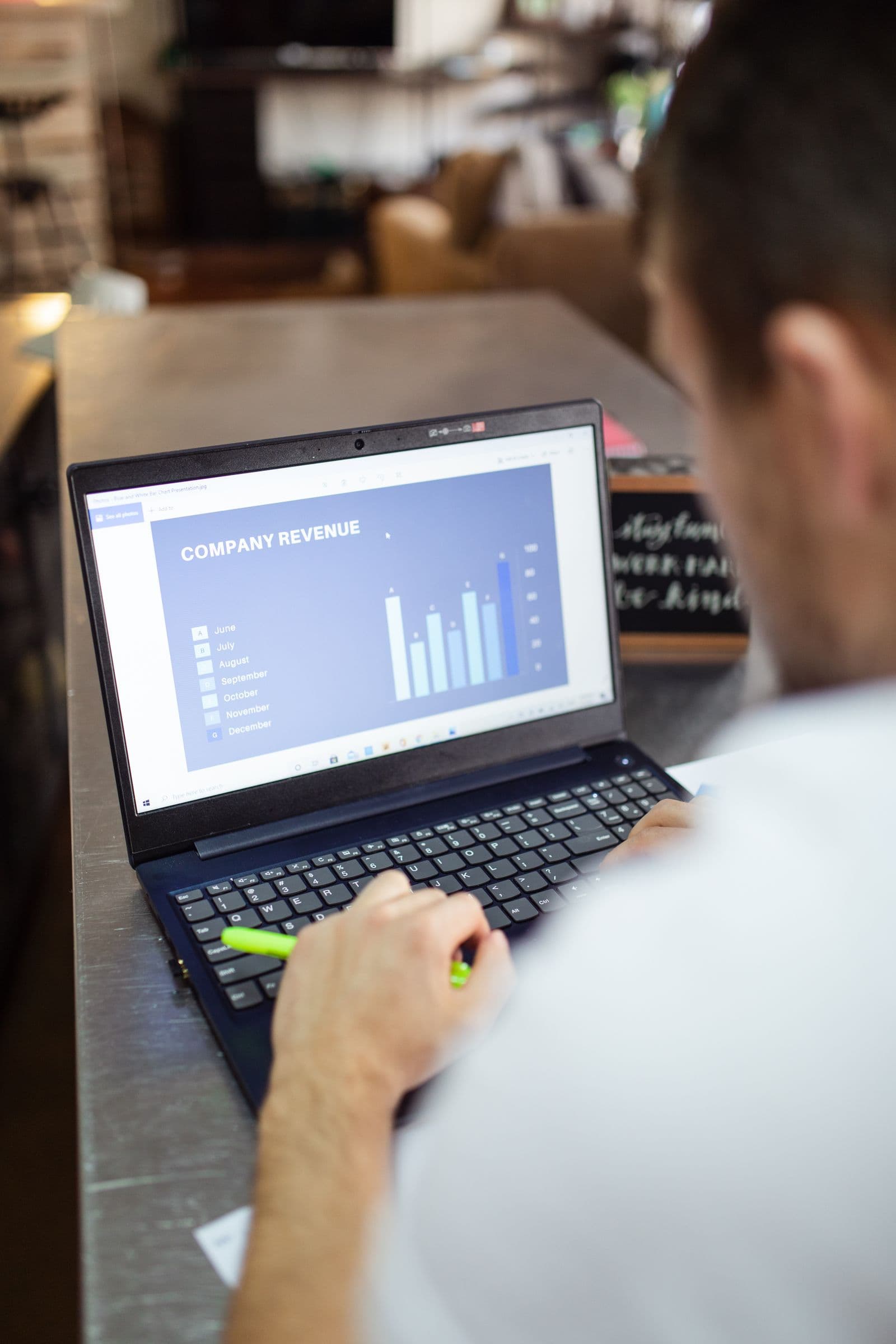 A person reviewing a revenue dashboard on a laptop with a pen in hand, standing in for the human approval step in mcp tool action approval