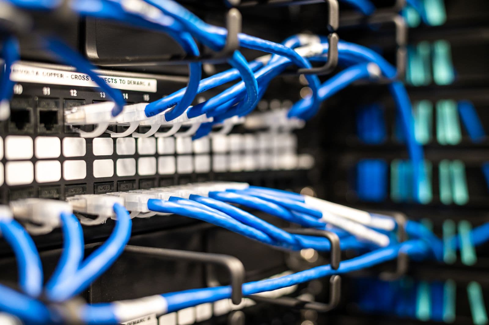 Blue ethernet patch cables plugged into a network switch, representing how an mcp gateway routes traffic between many servers and many clients