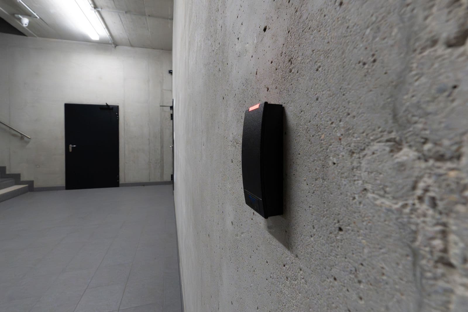 A keycard reader mounted beside a locked door, standing in for mcp authorization checked at the door rather than at the building entrance