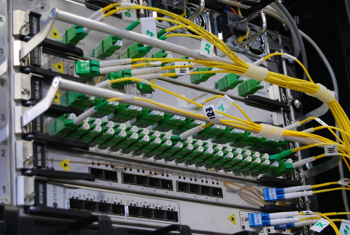 Fibre optic cables plugged into a network switch in a server rack, standing in for the way an mcp proxy sits between many clients and many upstream servers