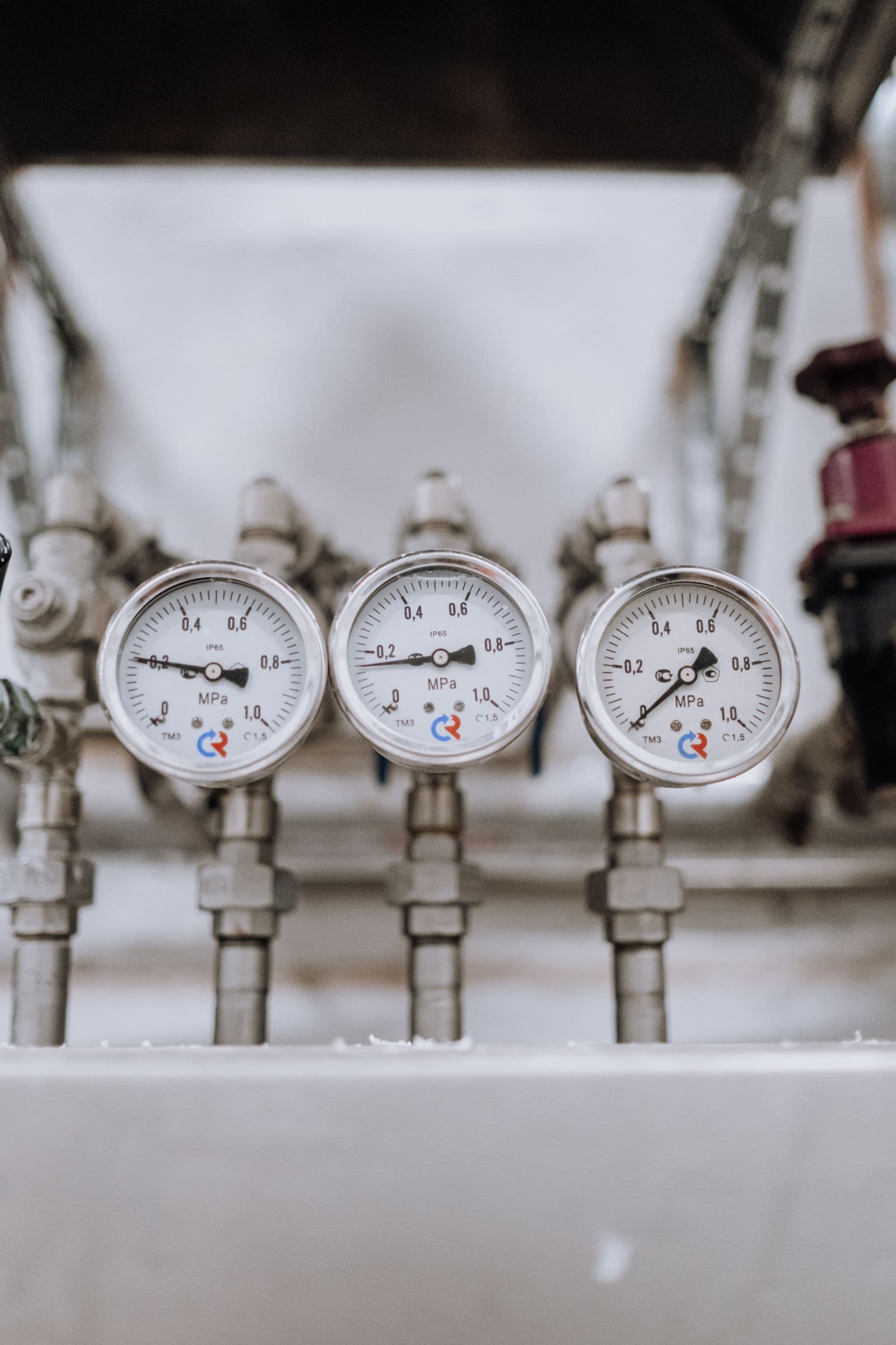 Three analog pressure gauges side by side on industrial pipework, standing in for mcp server monitoring across several connected servers at once